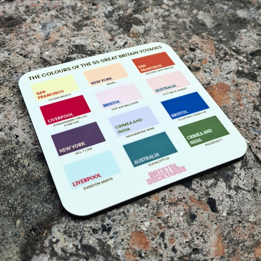 A square cream coloured coaster with the text 'THE COLOURS OF THE SS GREAT BRITAIN VOYAGES' with 12 coloured swatches labelled with some of the ship's destinations. The labels includes names such as San Francisco, Liverpool, Bristol, Australia, and New York.