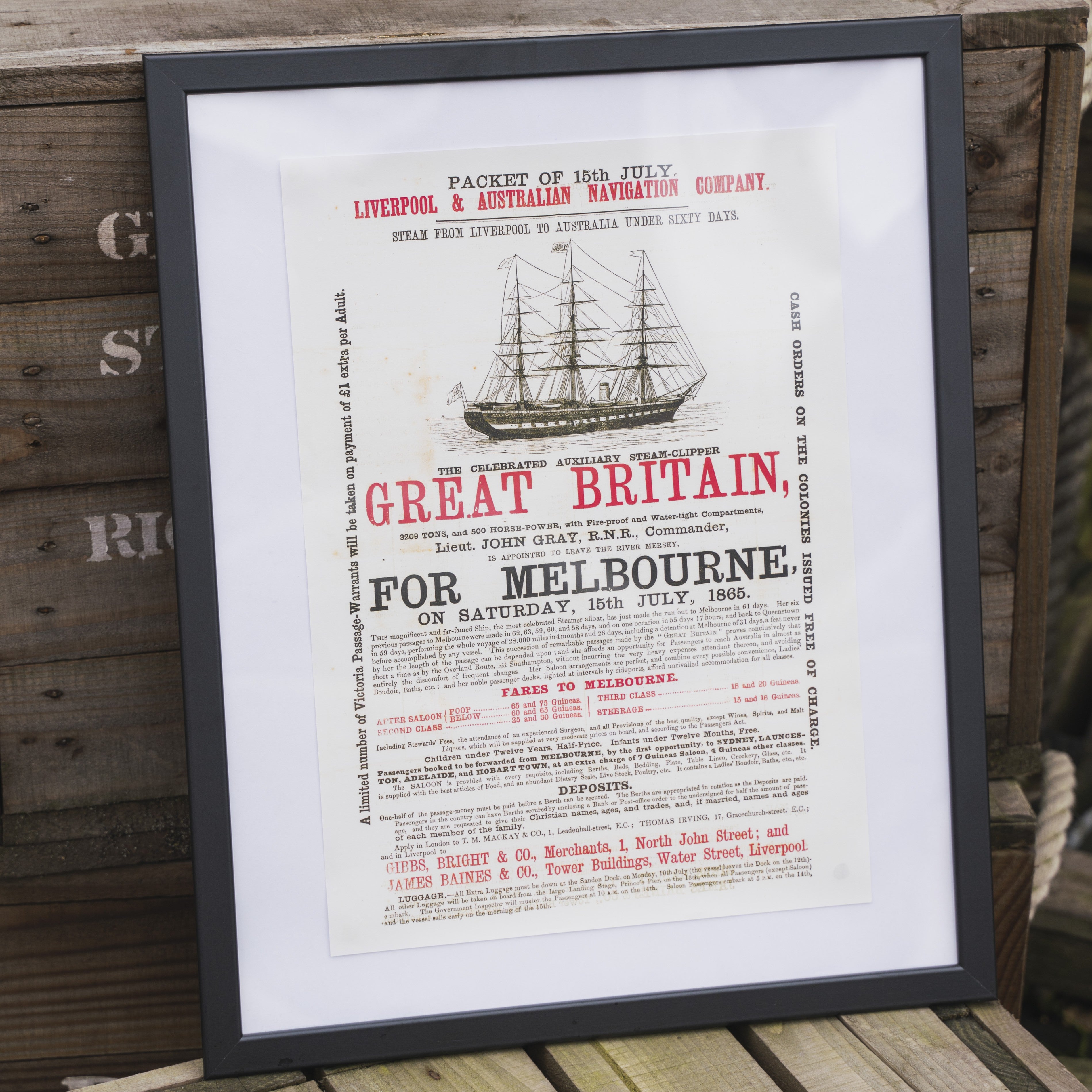 A framed print poster featuring a vintage advertisement for the SS Great Britain steamship with bold red and black text on a beige background.
