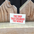 A pale green fridge magnet with the text 'The Ship That Changed the World' in orange lettering.